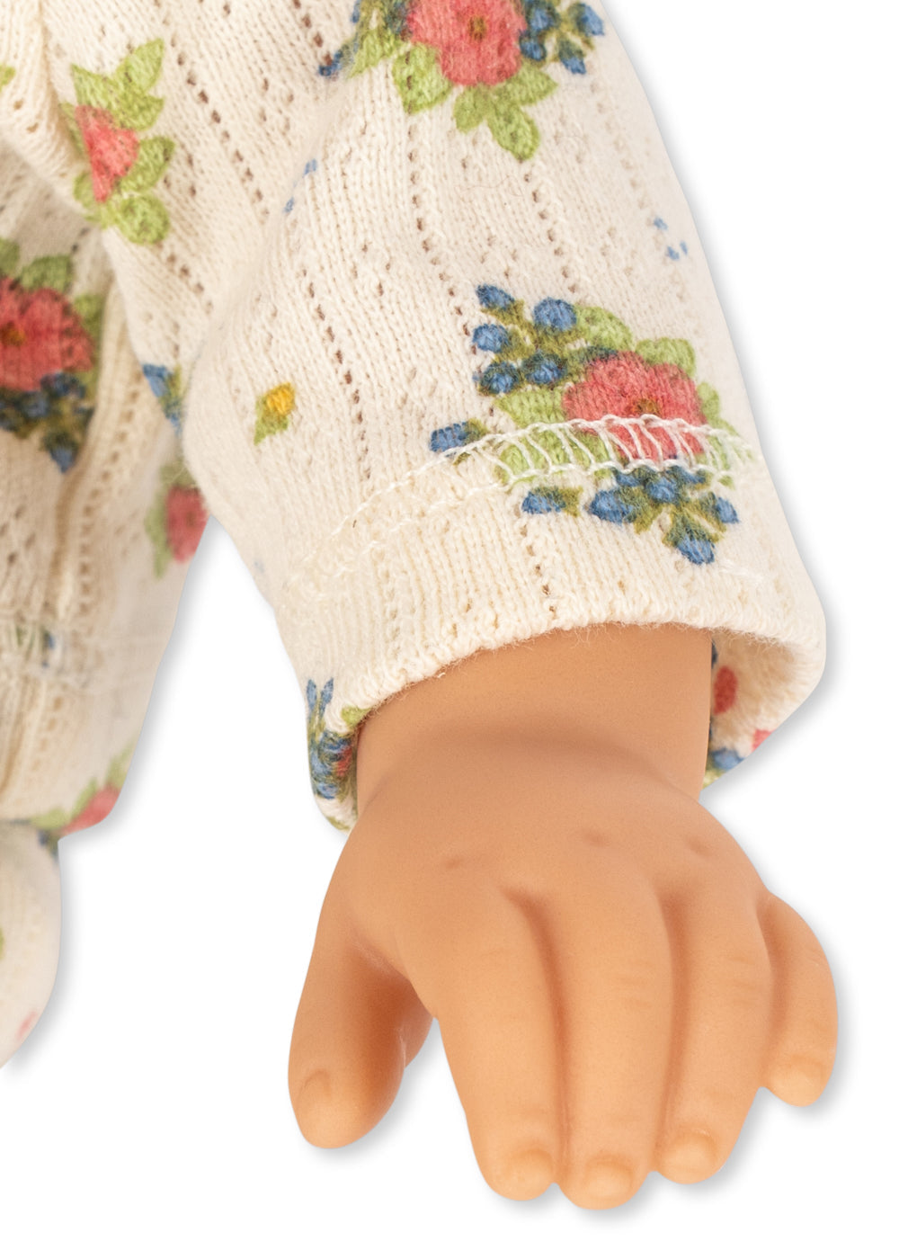 Close-up of a hand wearing a cream-colored glove with floral patterns on a white background