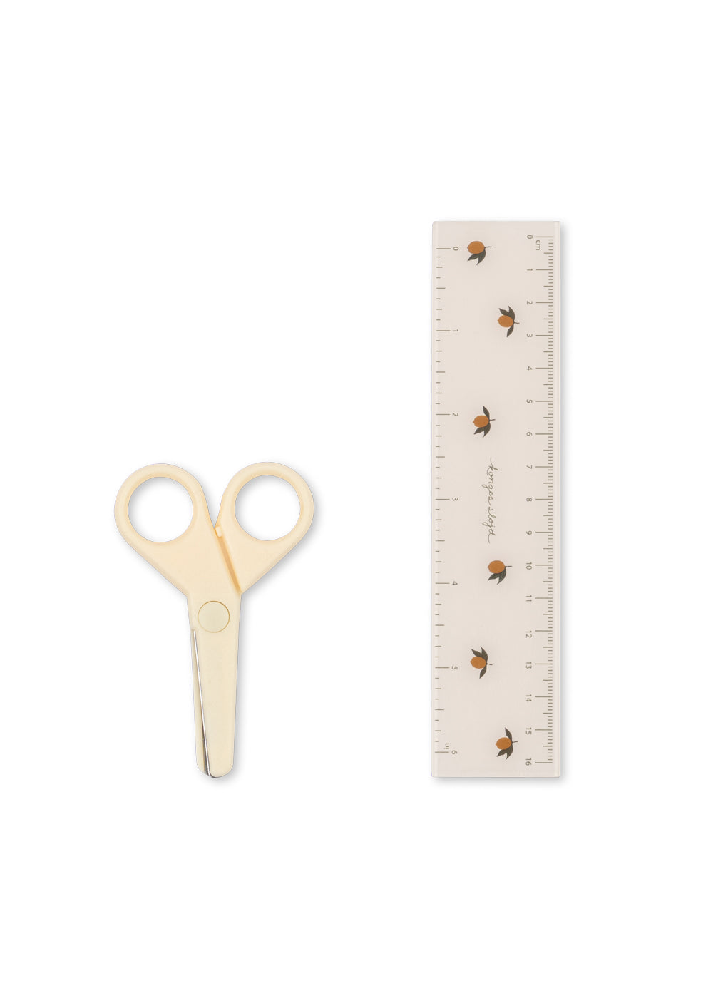 Pair of beige scissors next to a ruler on a white background