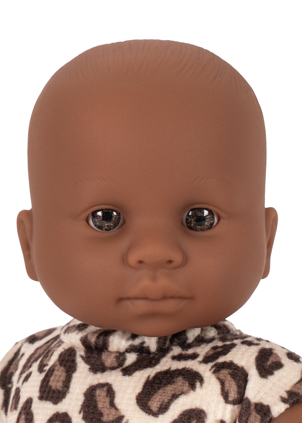 Close-up of a doll head with brown skin and dark eyes on a white background