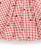 Red and white checkered fabric with small red flower patterns on a white background