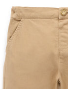 Close-up of beige pants with a button on a white background