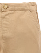 Close-up of beige pants with a button on a white background