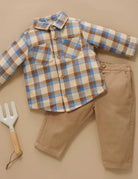 Plaid shirt and beige pants with a garden fork on a beige background