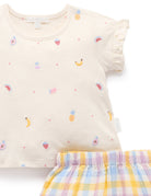 Beige top with fruit patterns and plaid shorts on a white background