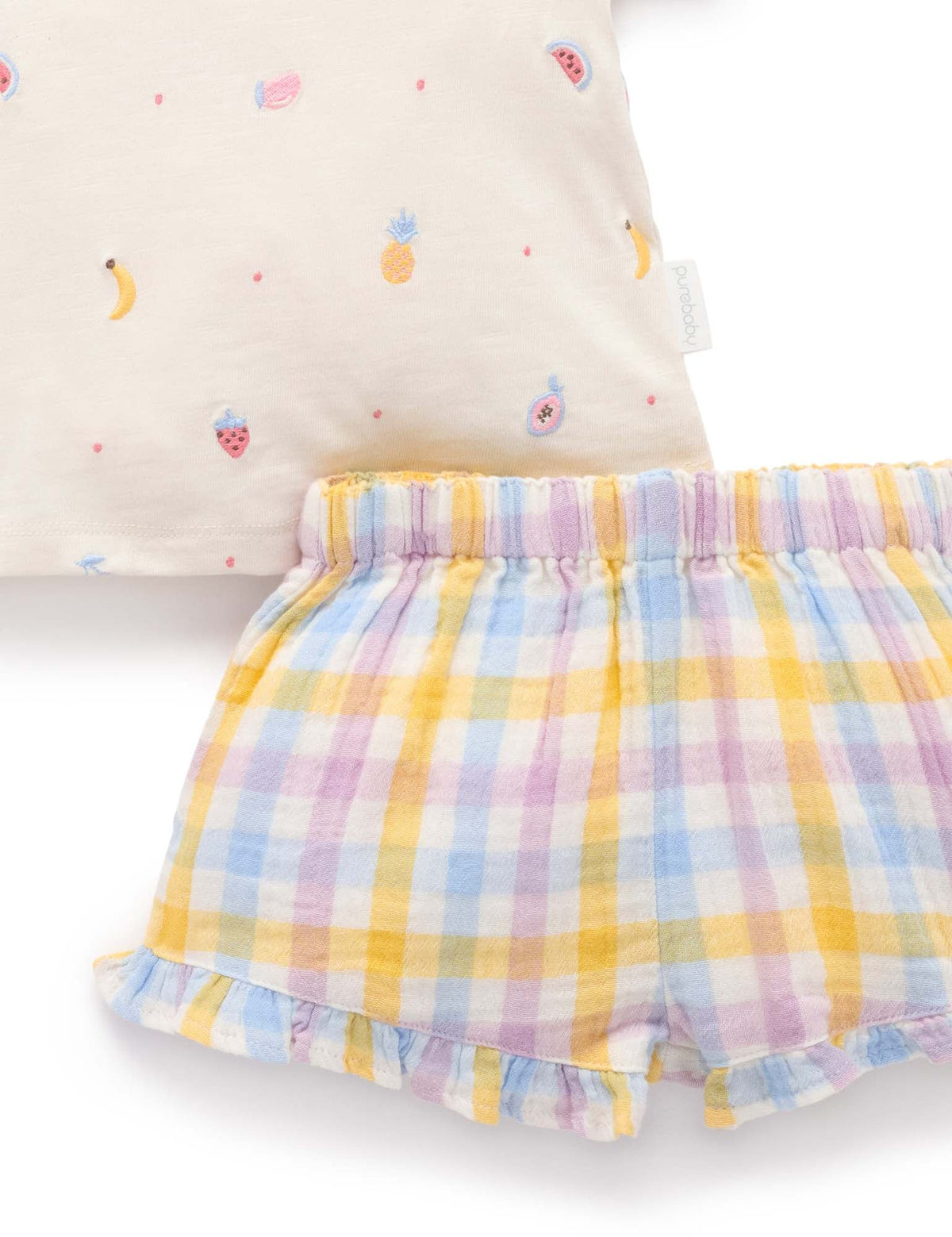 Pastel checkered shorts with a colorful pillow in the background