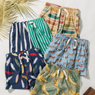 Collection of colorful children's shorts with various patterns on a white background.