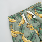 Green shorts with banana pattern on a light gray background
