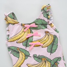 Pink tank top with banana and leaf pattern on a light gray background