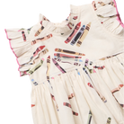 Close-up of a cream-colored children's dress with a colorful crayon print.