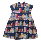 A sleeveless navy blue dress with a high gathered neckline and a full skirt, featuring an all-over print of vintage book spines, globes, clocks, and small illustrated objects in pink, red, yellow, and cream tones.