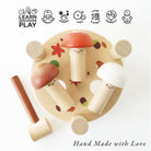 Wooden toy with mushroom designs on a white background, featuring icons and text about learning and play.