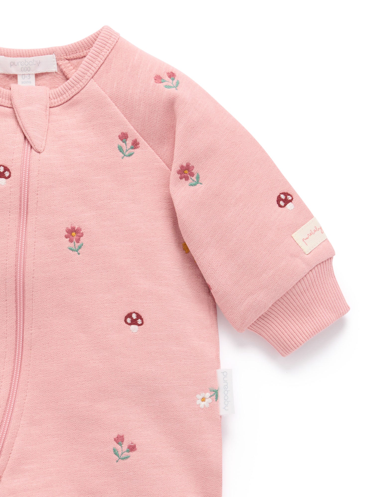 Pink baby outfit with floral embroidery on a white background