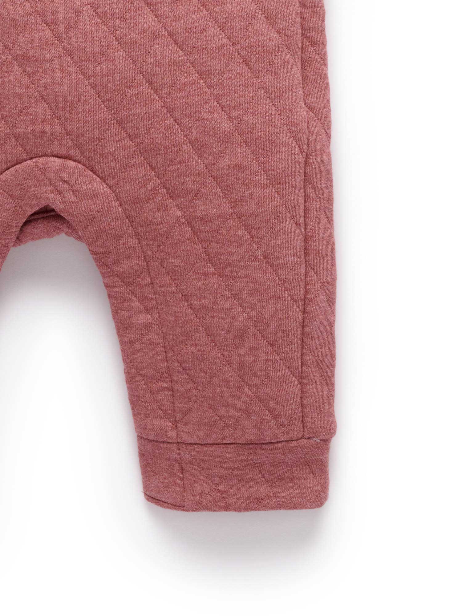 Quilted pink baby pants on a white background