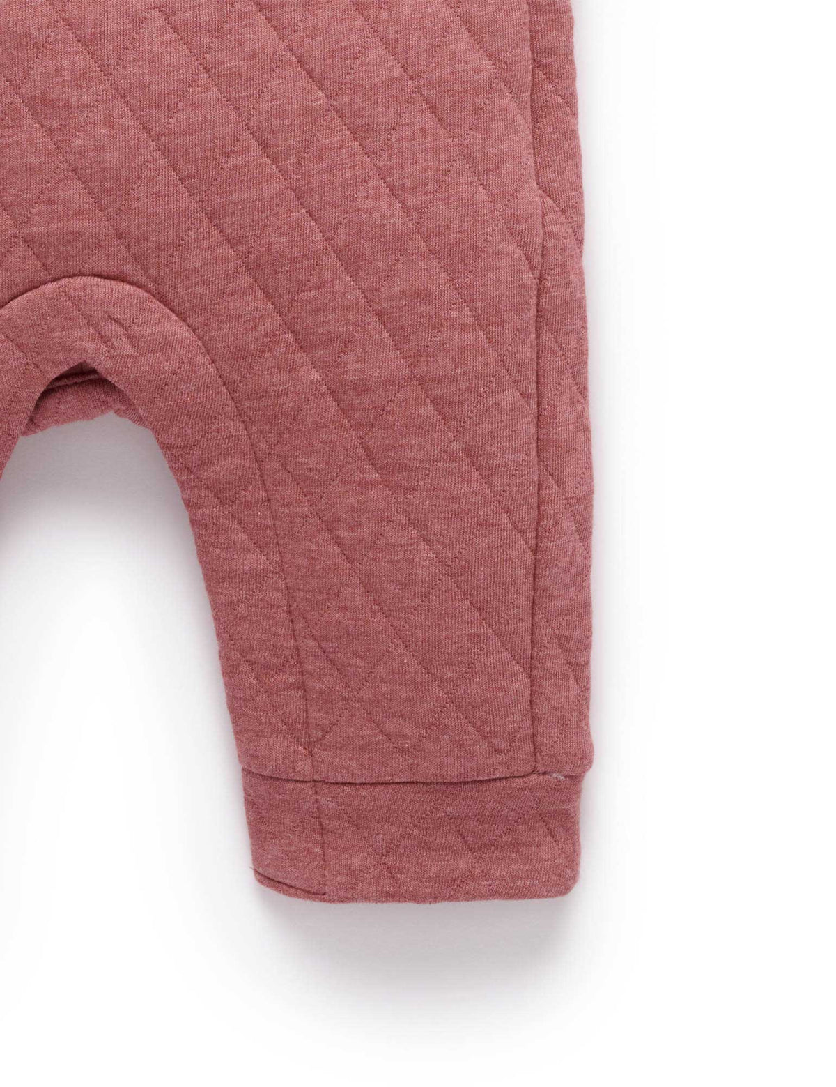 Quilted pink baby pants on a white background