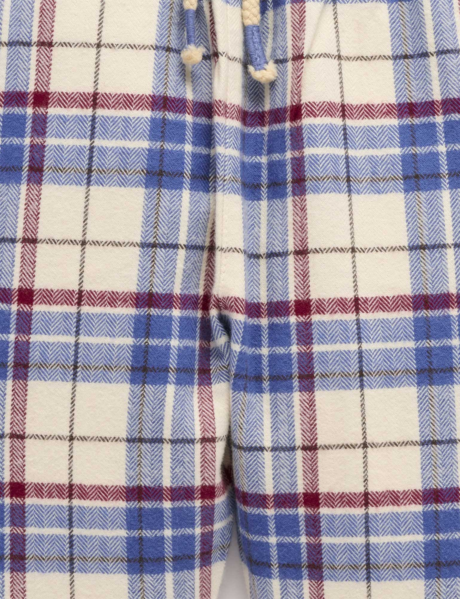 Close-up of a plaid fabric with blue, red, and white colors.