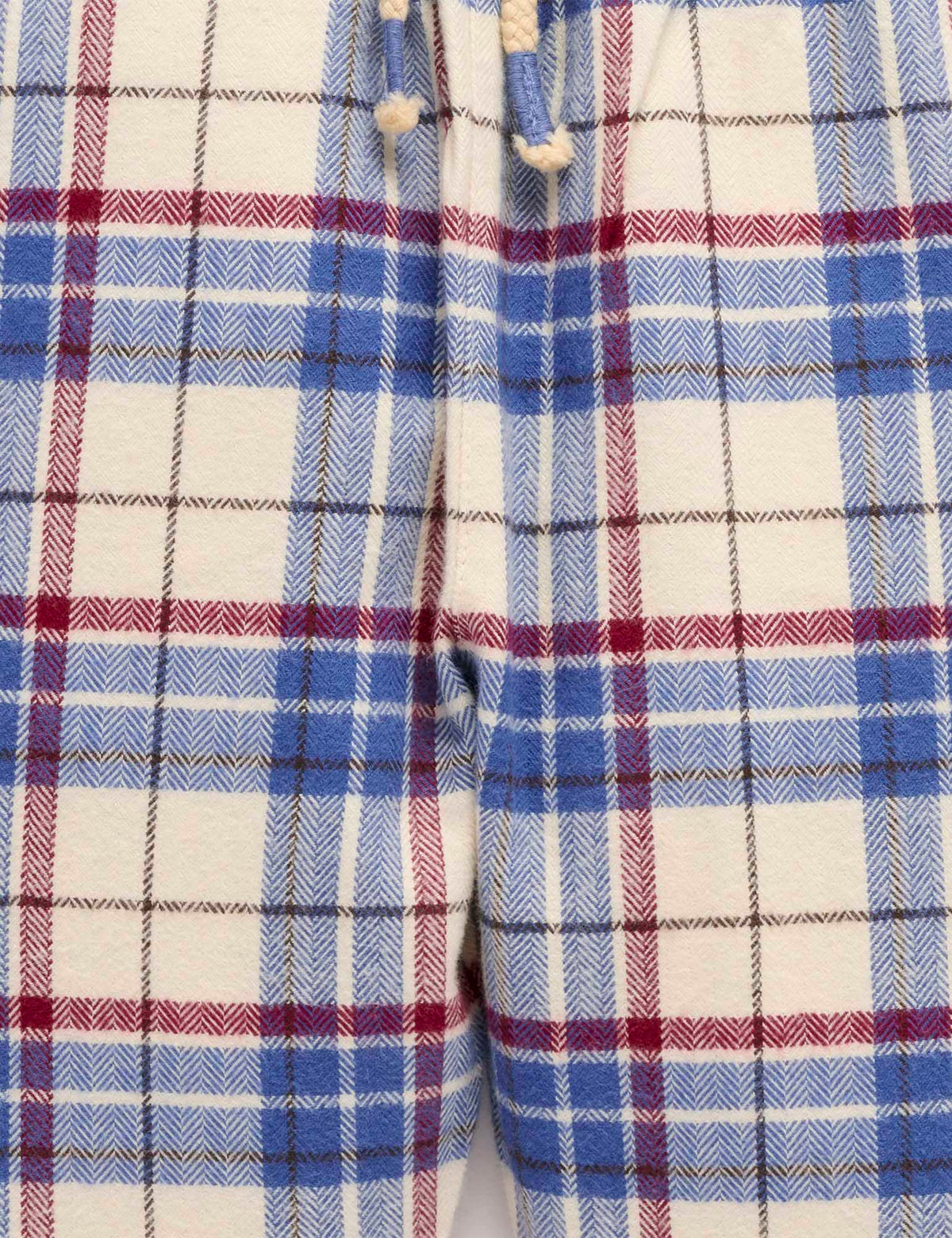 Close-up of a plaid fabric with blue, red, and white colors.