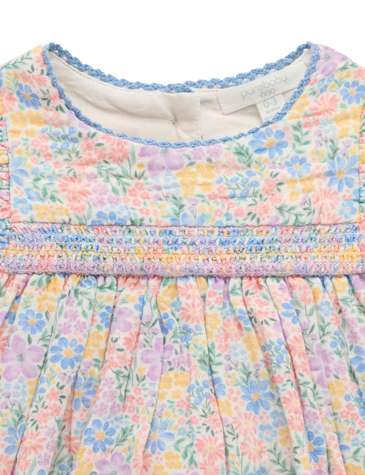 Close-up of a pastel floral dress with ruffled neckline
