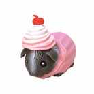 Small animal figurine wearing a pink ice cream cone costume on a white background