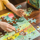 Child playing with a dinosaur-themed puzzle on a wooden table