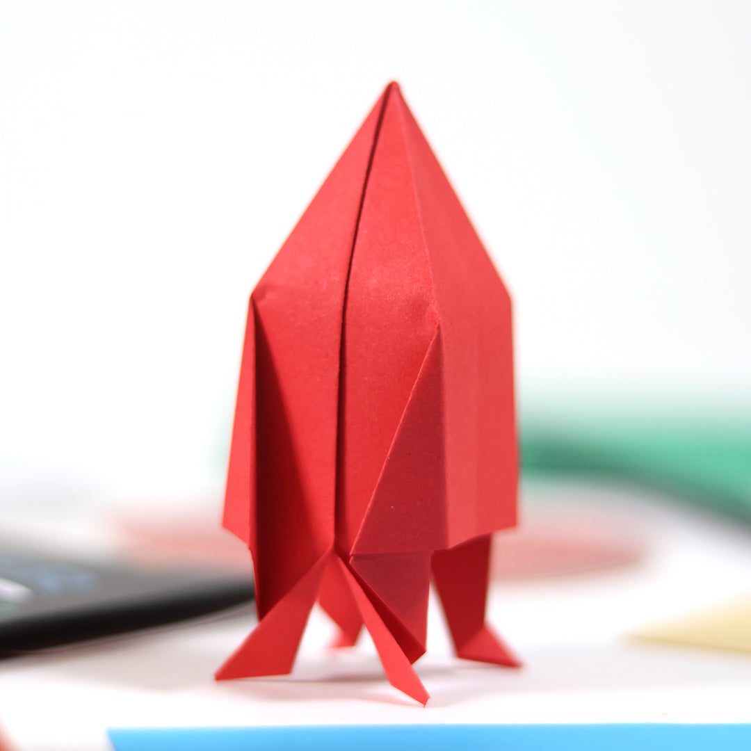 Red origami figure on a blurred background