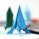 Blue paper airplane on a car dashboard with blurred background