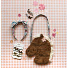 Horse-shaped plush toy with floral headband and hair accessories on a checkered background