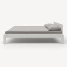 White bed frame with gray bedding on a white background