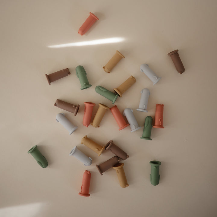 Colorful cylindrical objects scattered on a beige surface