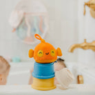 Orange fish-shaped bath toy with a blue base in a bathtub setting