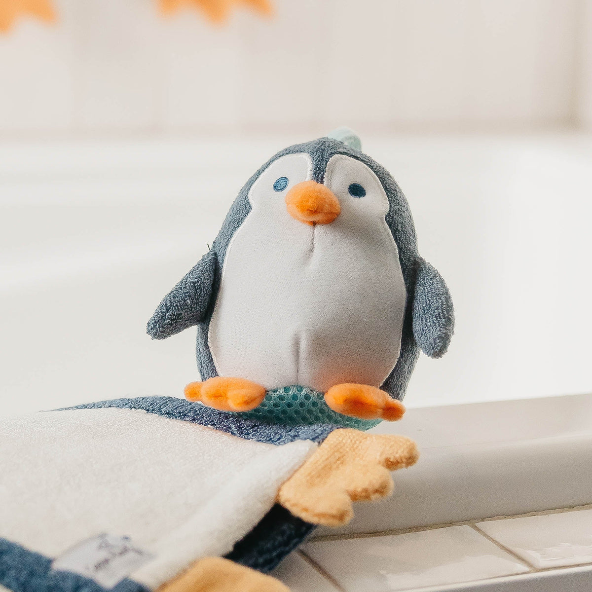 Plush penguin toy on a white surface with a soft focus background