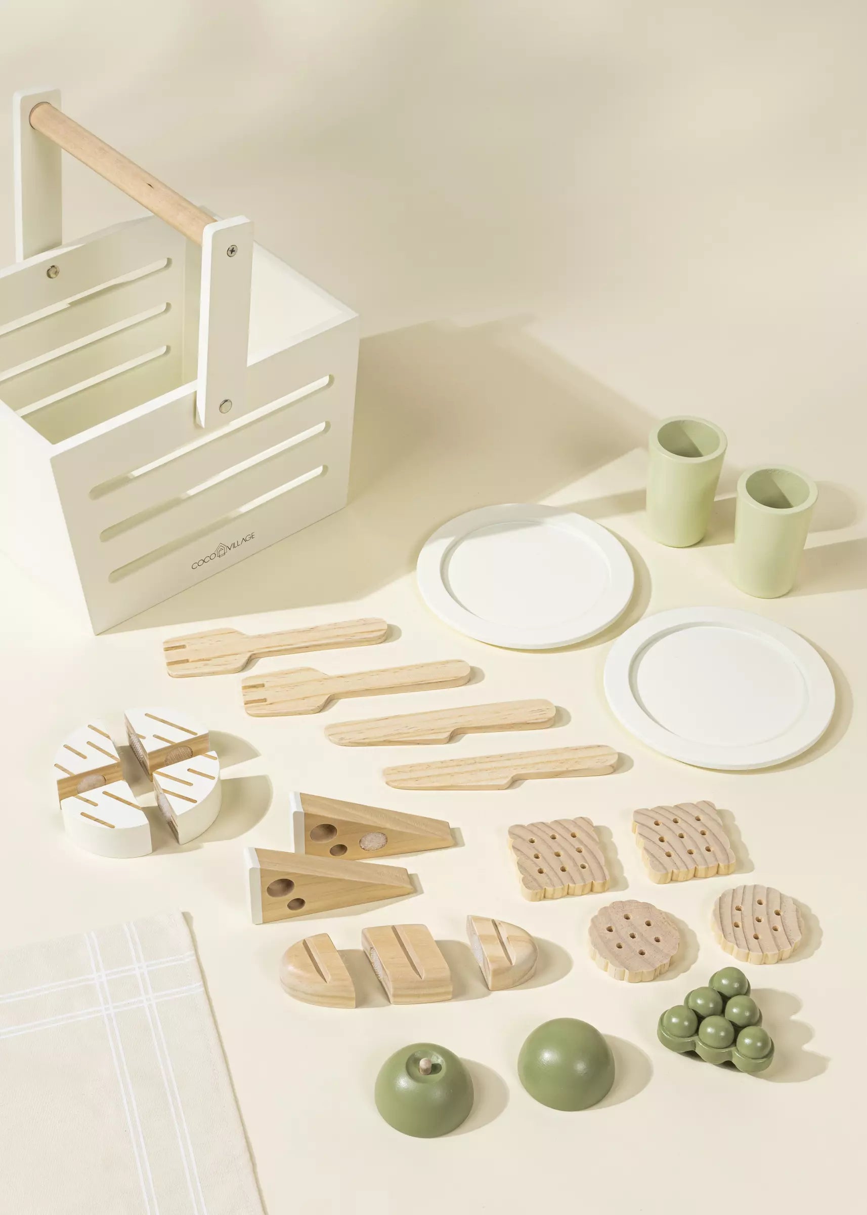Set of wooden kitchen utensils and items on a light surface with a white crate.