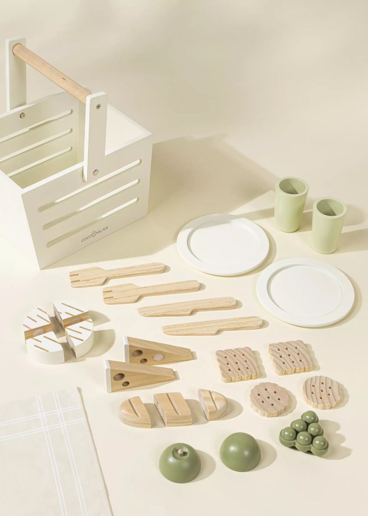 Set of wooden kitchen utensils and items on a light surface with a white crate.