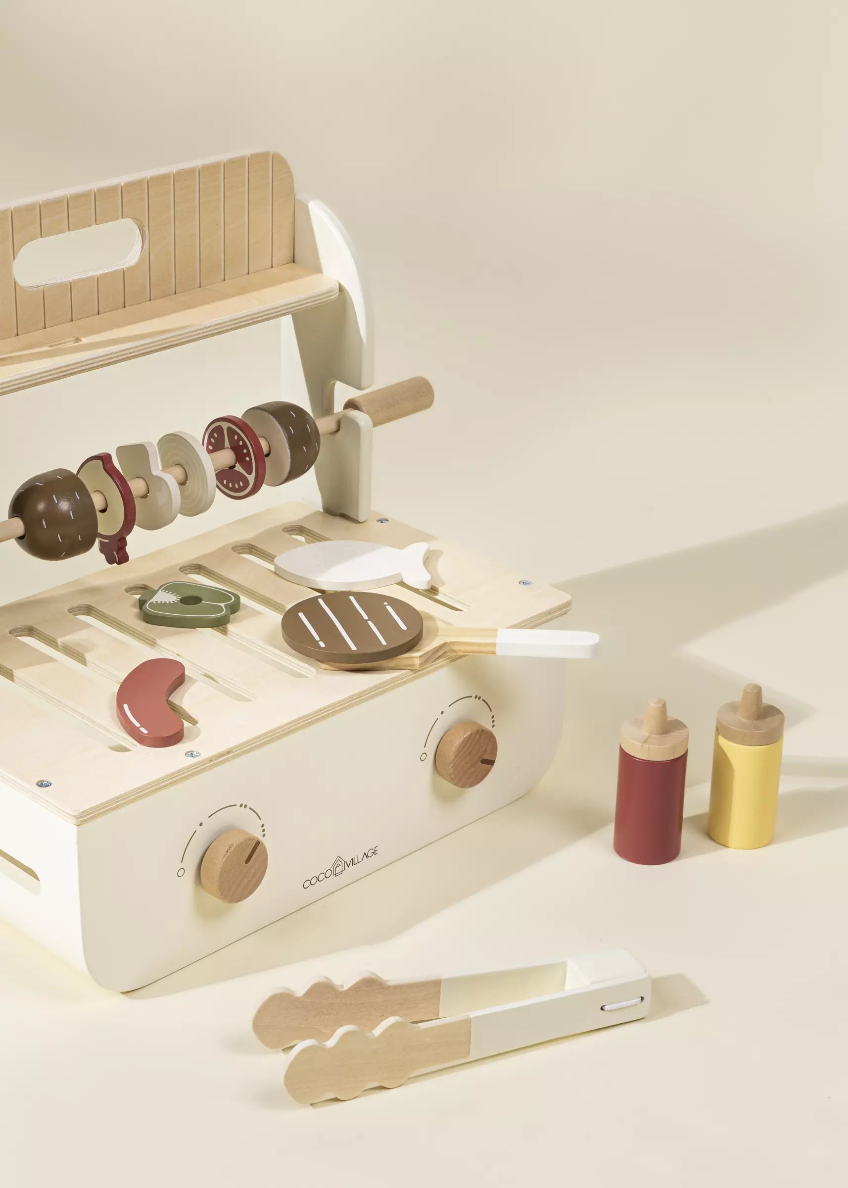 Wooden toy kitchen set with accessories on a light background
