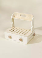 White and beige toy kitchen cart with wooden accents on a light background