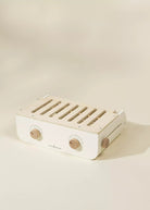 White electronic device with wooden accents on a beige background