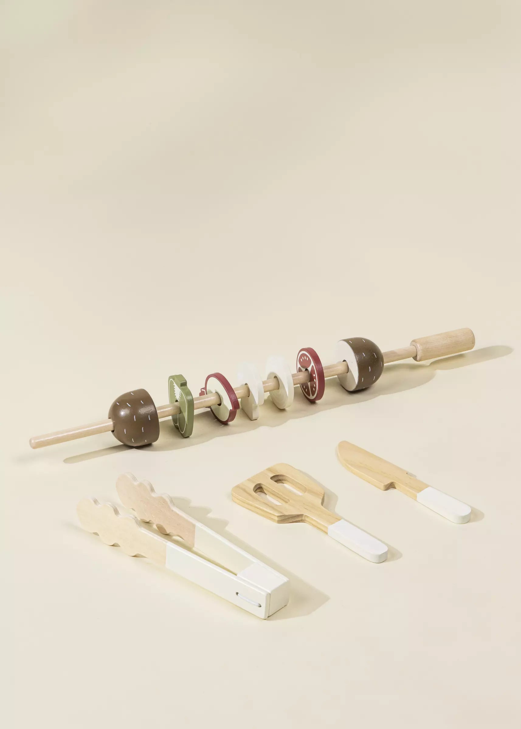 Set of wooden tools including a rod with attachments on a beige background
