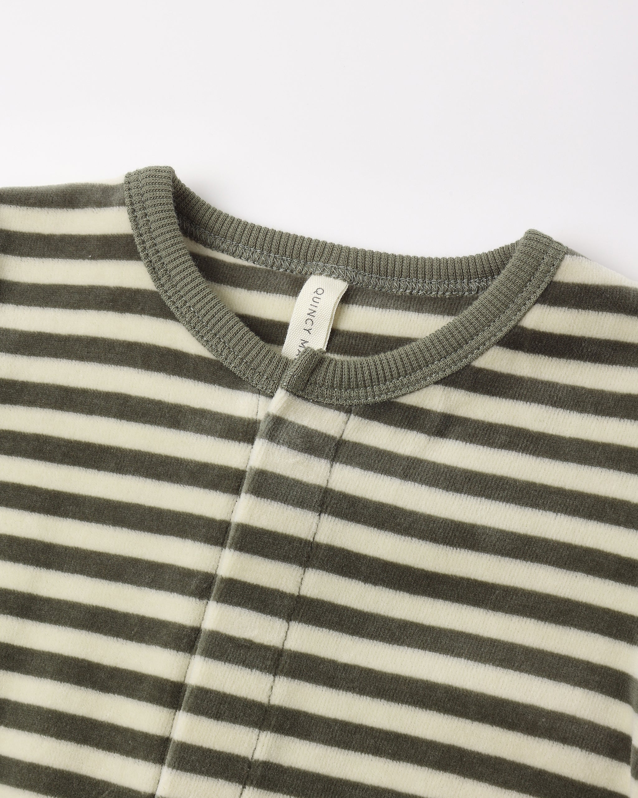 Close-up view of the neckline and collar of a long-sleeve baby footie featuring a green and white horizontal stripe pattern with a solid green ribbed collar and a small brand tag inside.