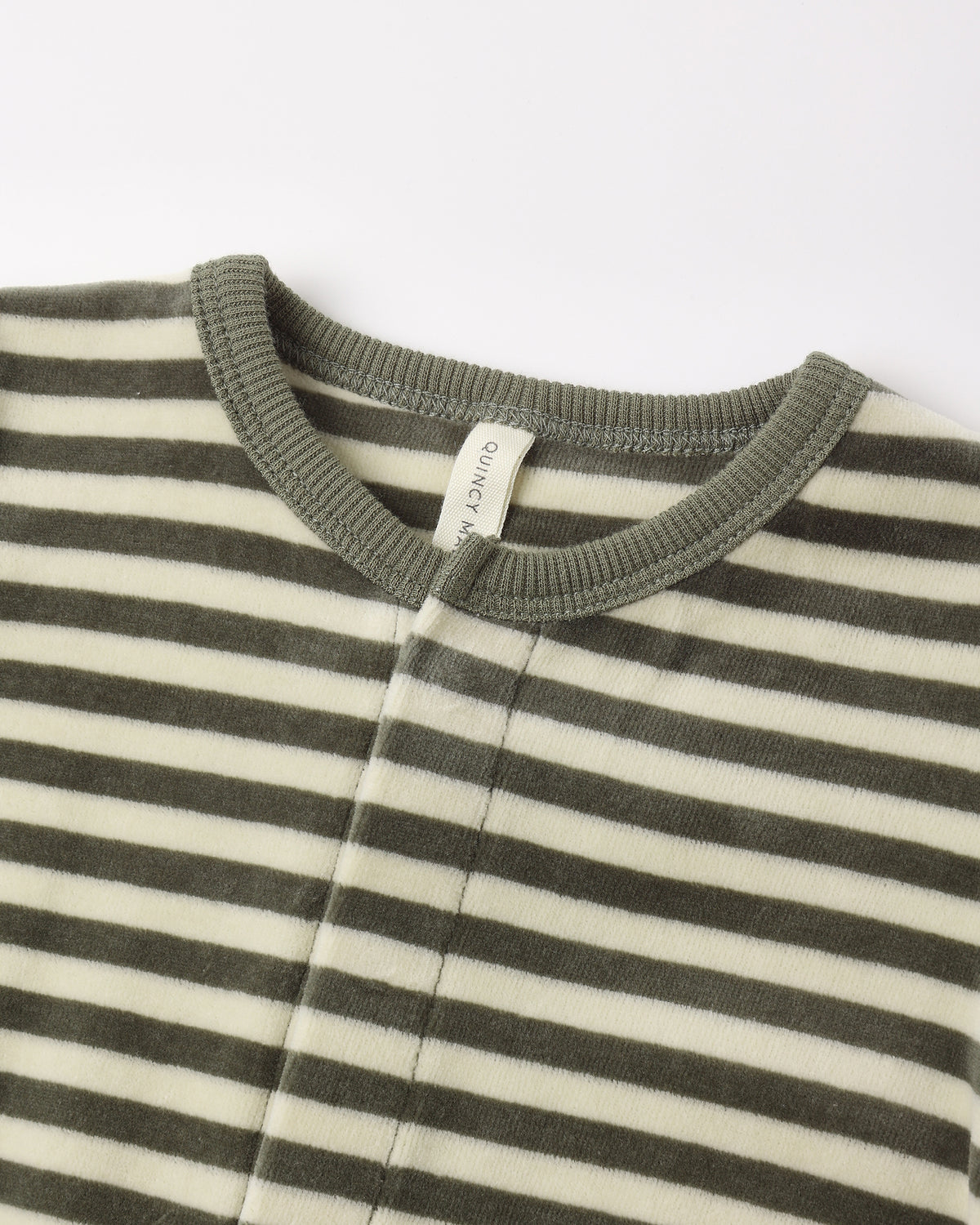 Close-up view of the neckline and collar of a long-sleeve baby footie featuring a green and white horizontal stripe pattern with a solid green ribbed collar and a small brand tag inside.