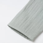 Close-up of a light gray fabric edge on a white background