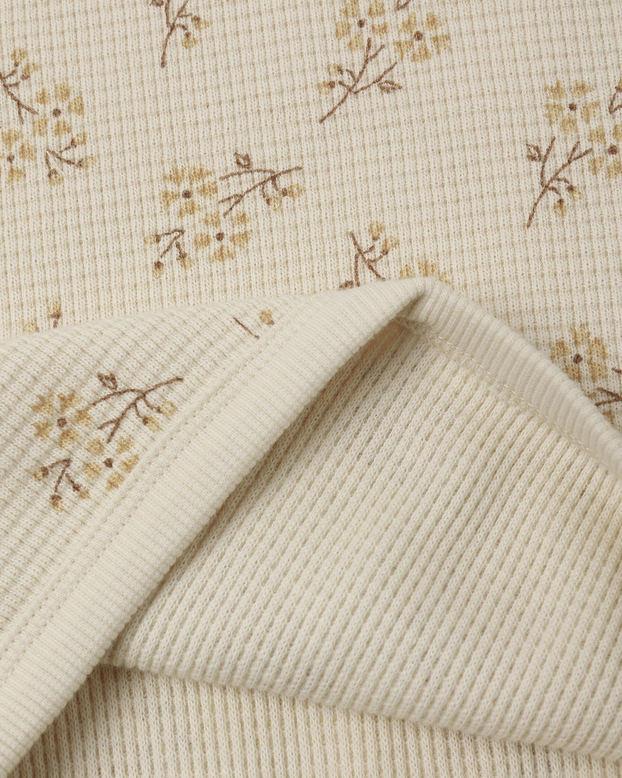 An off-white ribbed fabric with a delicate yellow floral ditsy print from Rylee + Cru.