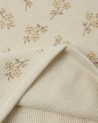 An off-white ribbed fabric with a delicate yellow floral ditsy print from Rylee + Cru.