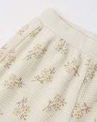 An off-white ribbed cotton toddler legging featuring a delicate, vintage-style small floral print with soft yellow and brownish stems.