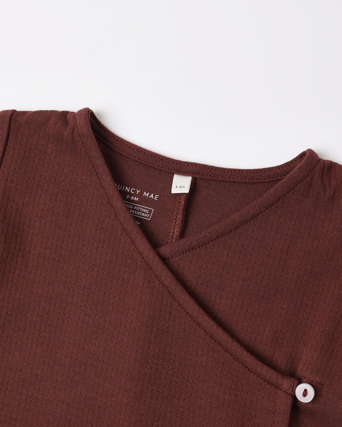 A dark brown Quincy Mae baby wrap-around top featuring a side button closure.