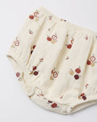 Cream-colored cotton diaper cover with a red and brown apple print, shown on a plain white background.