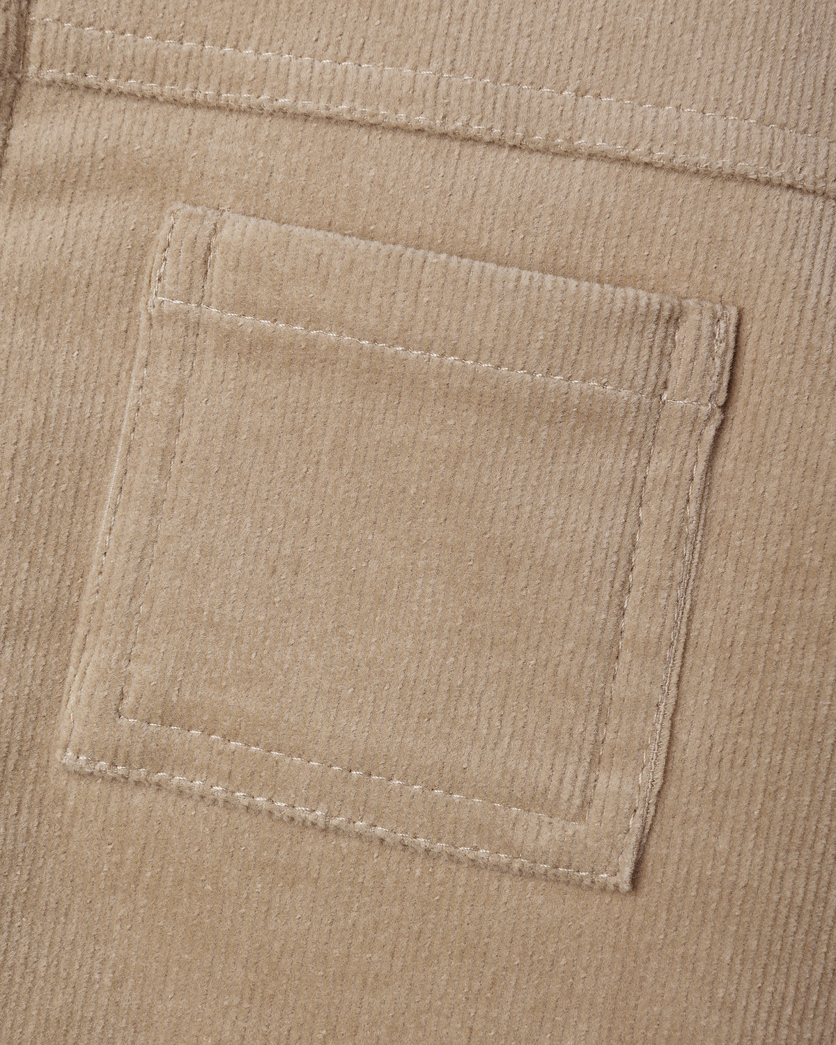 Close-up detail of the front patch pocket on the Ezrah Jacket in latte corduroy by Quincy Mae.