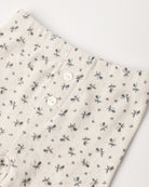 A pair of cream-colored pointelle cotton baby leggings featuring a delicate ditsy floral print and decorative front buttons