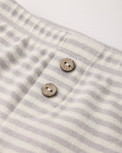 Close-up of the light gray and white fog stripe waffle knit fabric with two wooden buttons on the Quincy Mae Take Home Set.