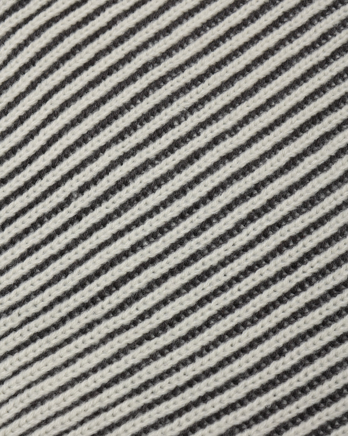 Close-up of a woven fabric with diagonal stripes in off-white and dark charcoal gray.