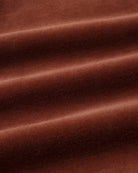 Close-up shot of soft, plush redwood brown velour fabric showing rich texture and gentle folds.