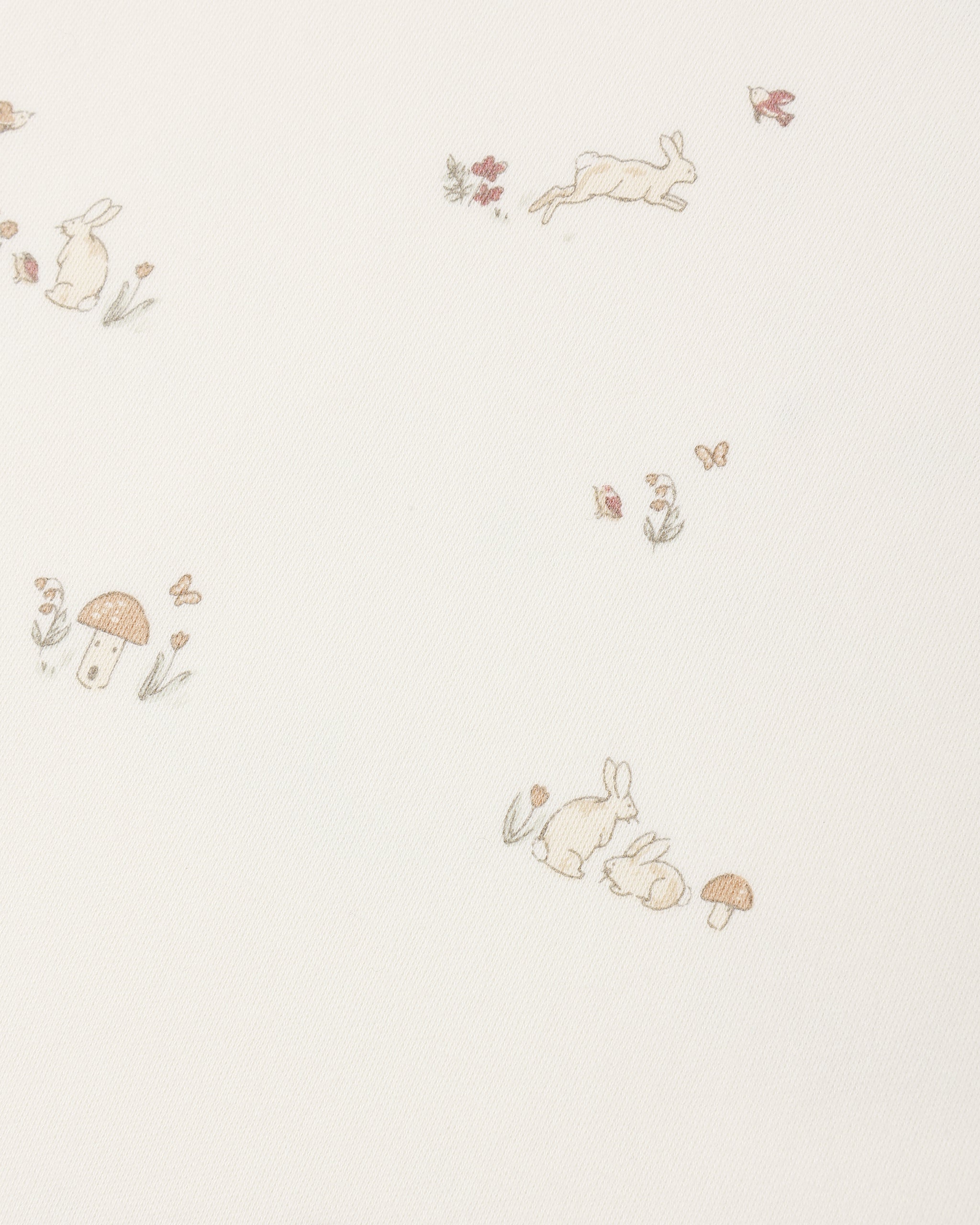 A close-up of a cream-colored fabric or wallpaper featuring a delicate, repeating pattern of small rabbits, mushrooms, flowers, and butterflies in soft beige, muted brown, and pale green tones.